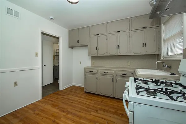 a kitchen with stainless steel appliances white cabinets and a stove top oven