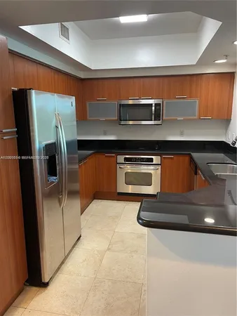 a kitchen with stainless steel appliances granite countertop a sink a stove and a refrigerator