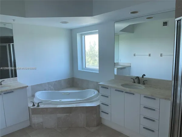 a bathroom with a granite countertop sink and bathtub