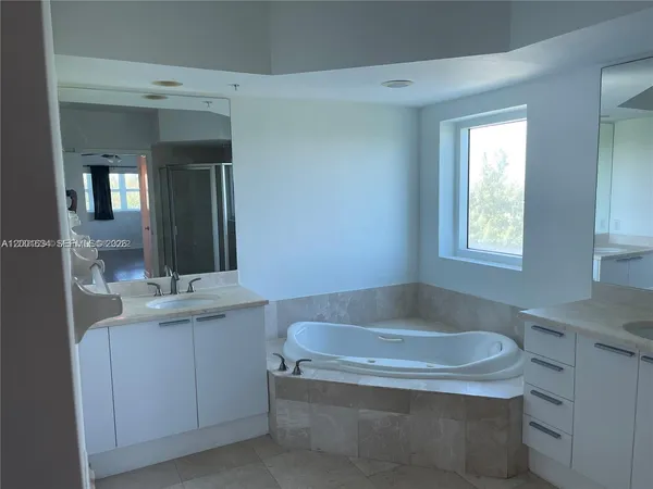 a bathroom with a bathtub sink and mirror