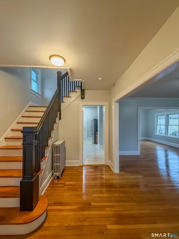 a view of entryway and hall with wooden floor