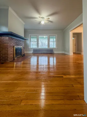 a view of empty room with wooden floor and fireplace