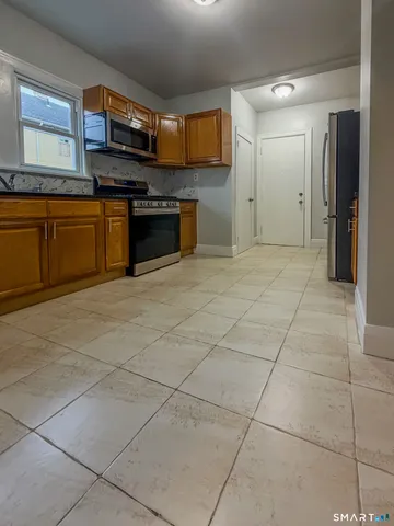 a large kitchen with cabinets and steel stainless steel appliances