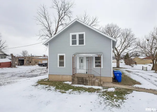 a view of a house with a yard covered in snow
