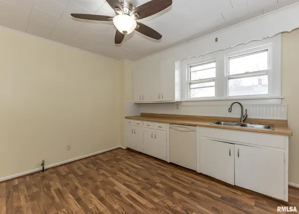 a view of a kitchen with a sink hardwood floor and a window