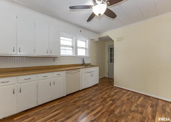 a kitchen with granite countertop white cabinets and white appliances