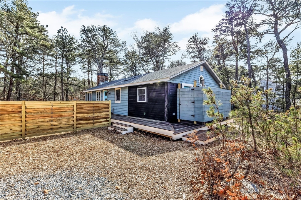 a view of a house with a yard and wooden fence