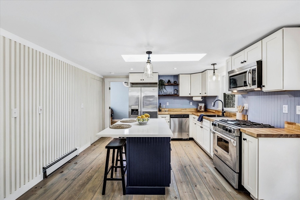 55 Howes Road Wellfleet, MA 02667 - Photo 12 of 33 a kitchen with kitchen island granite countertop a sink cabinets and stainless steel appliances