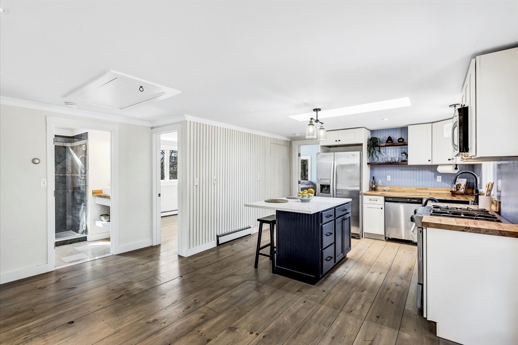 55 Howes Road Wellfleet, MA 02667 - Photo 19 of 33 a kitchen with stainless steel appliances granite countertop a stove a sink dishwasher and a refrigerator with wooden floor