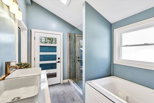 a bathroom with a tub shower and sink