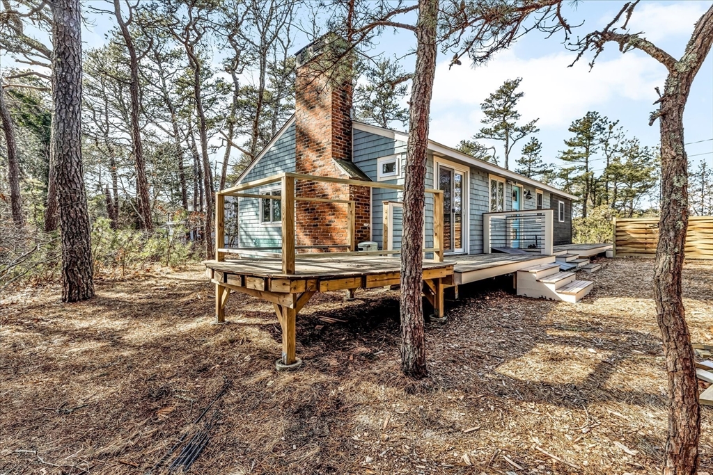55 Howes Road Wellfleet, MA 02667 - Photo 28 of 33 a backyard of a house with barbeque oven table and chairs