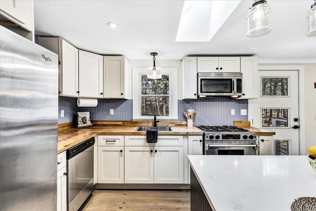 a kitchen with stainless steel appliances a stove a sink and a microwave