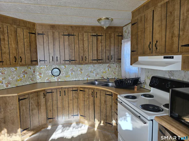 a kitchen that has a sink and a stove in it