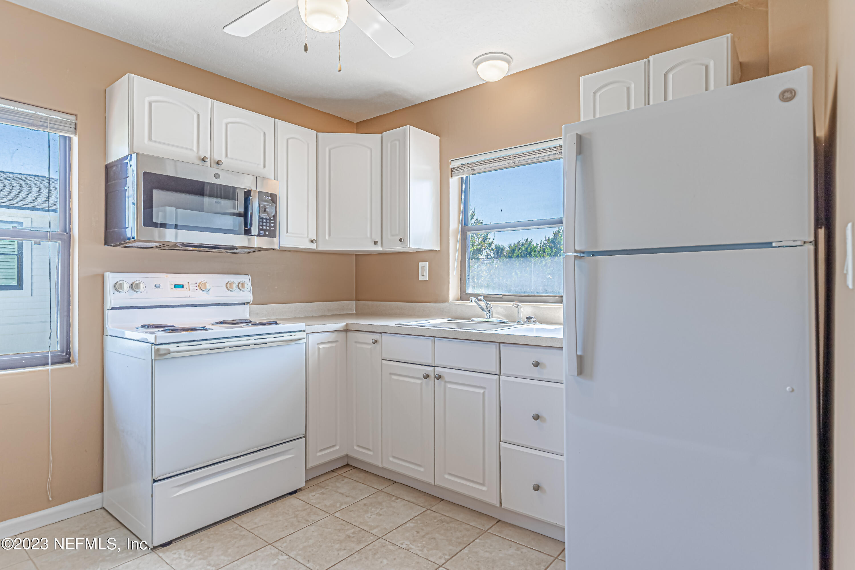 1907 First Street Neptune Beach, FL 32266 - Photo 11 of 29 a white refrigerator freezer sitting inside of a kitchen