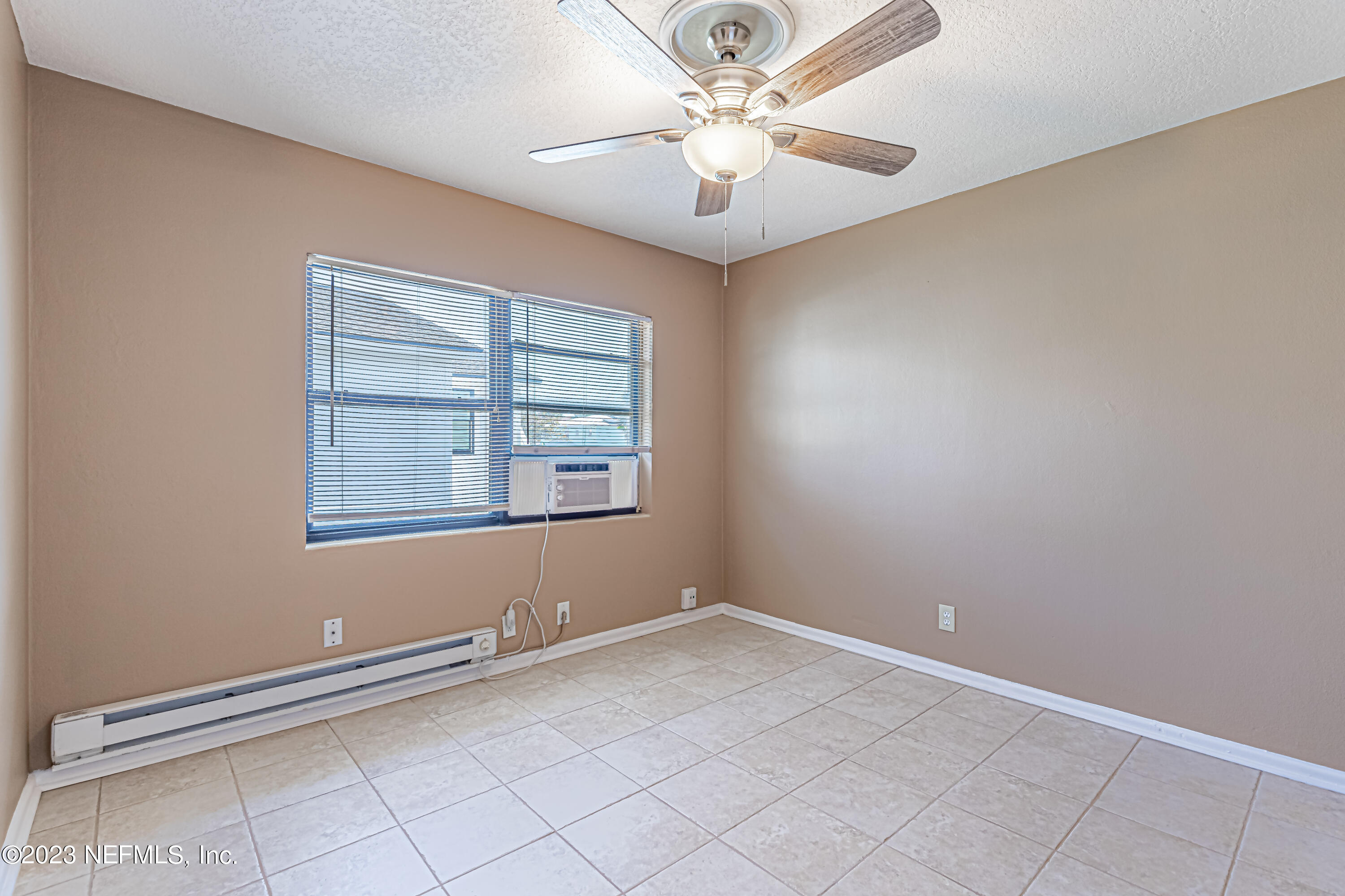 1907 First Street Neptune Beach, FL 32266 - Photo 14 of 29 an empty room with windows and fan