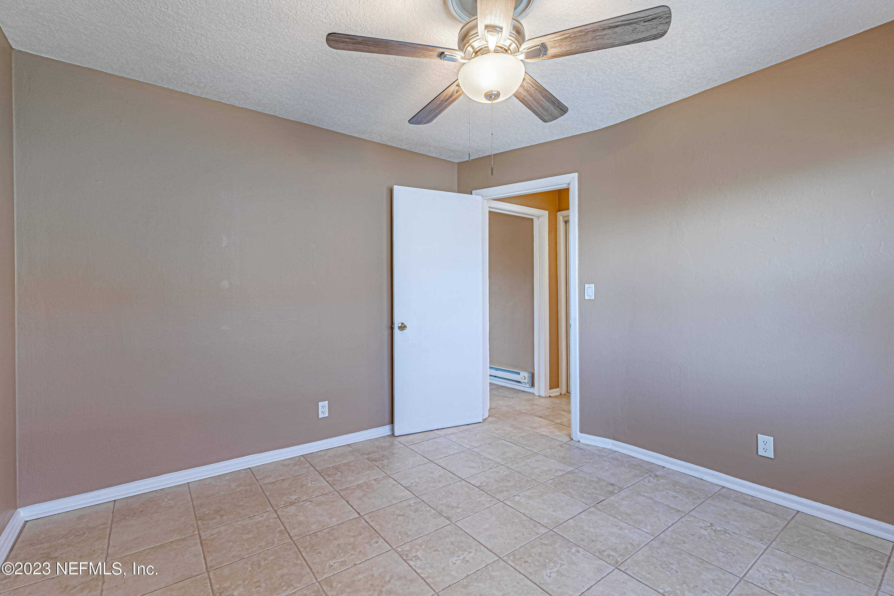 1907 First Street Neptune Beach, FL 32266 - Photo 15 of 29 an empty room with a chandelier fan and windows