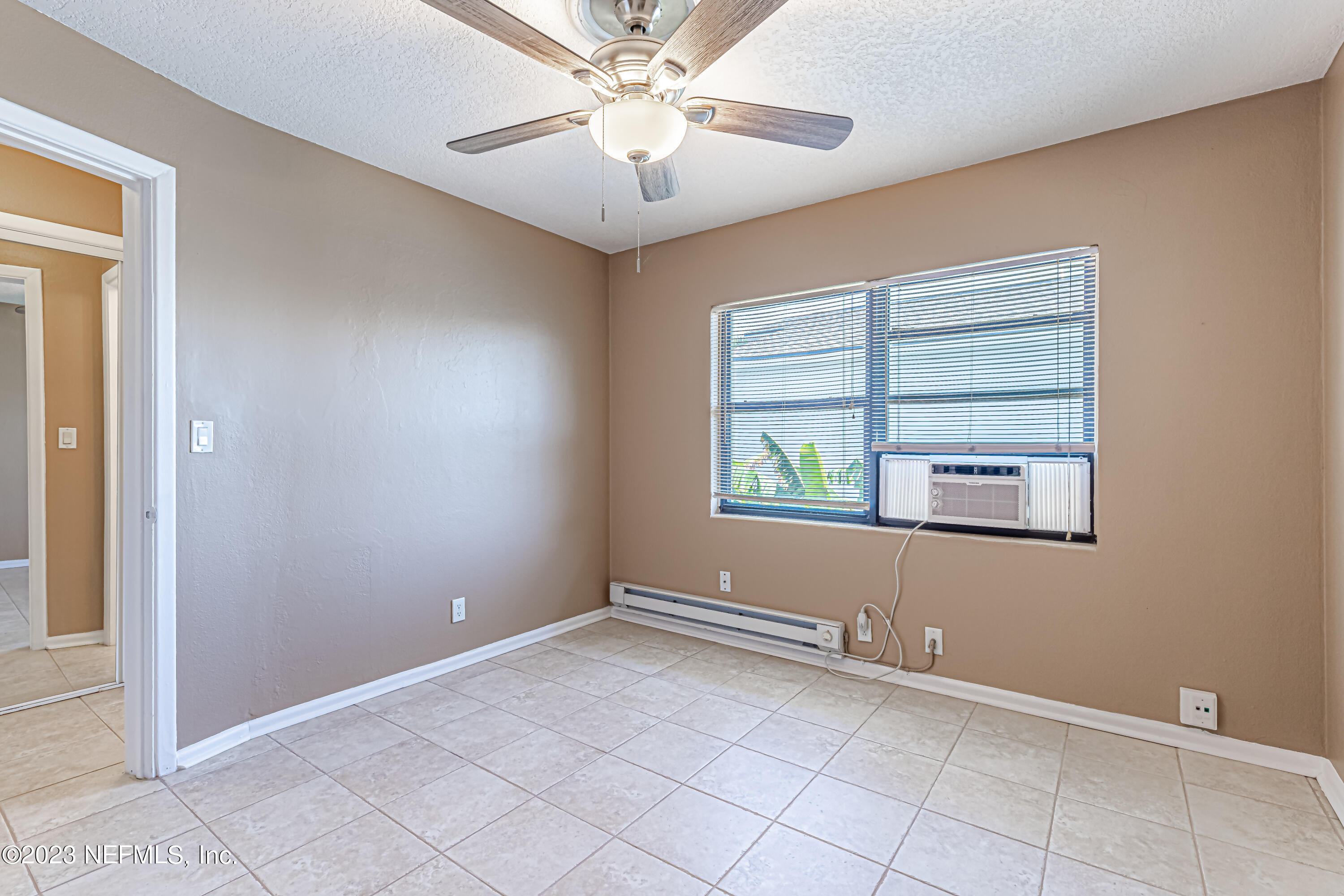 1907 First Street Neptune Beach, FL 32266 - Photo 17 of 29 an empty room with windows and fan