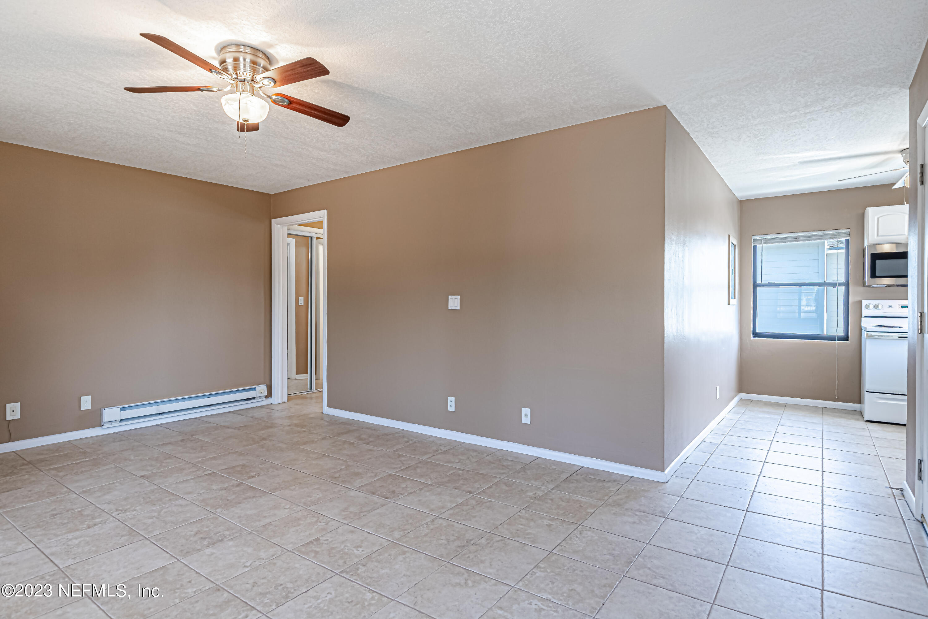 1907 First Street Neptune Beach, FL 32266 - Photo 9 of 29 a view of an empty room with a ceiling fan and window