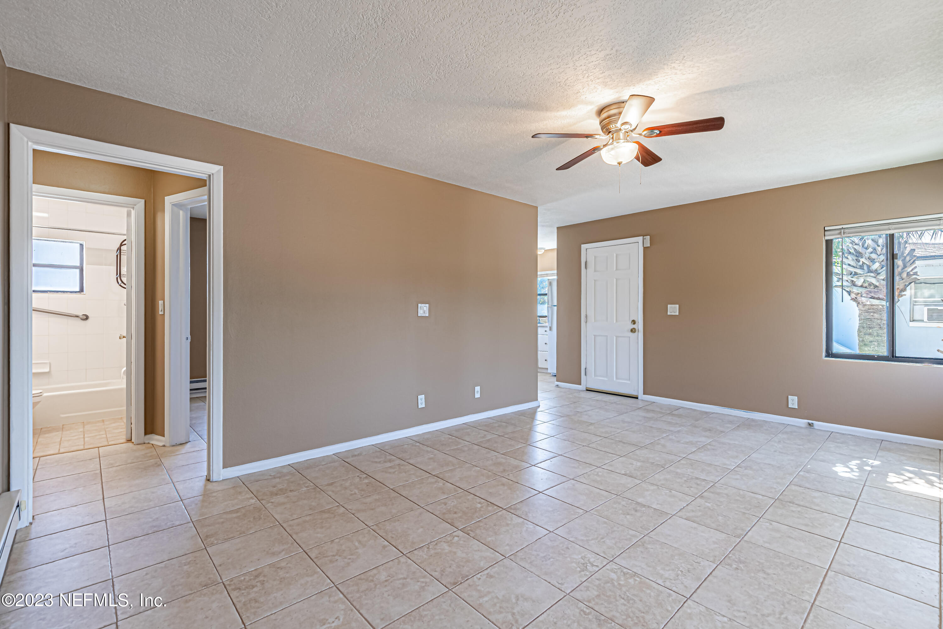 1907 First Street Neptune Beach, FL 32266 - Photo 10 of 29 a view of an empty room with window and chandelier fan