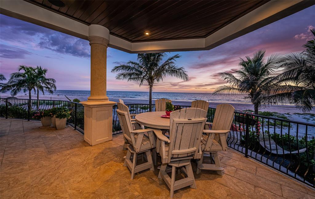 17824 Lee Avenue Redington Shores, FL 33708 - Photo 32 of 98 a view of a patio with table and chairs potted plants and palm tree