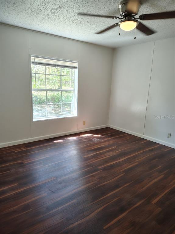 3440 County Road 656 Webster, FL 33597 - Photo 10 of 14 an empty room with wooden floor fan and windows