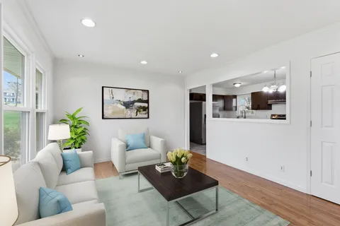 a living room with furniture and kitchen view