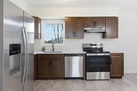 a kitchen with stainless steel appliances a sink stove and refrigerator