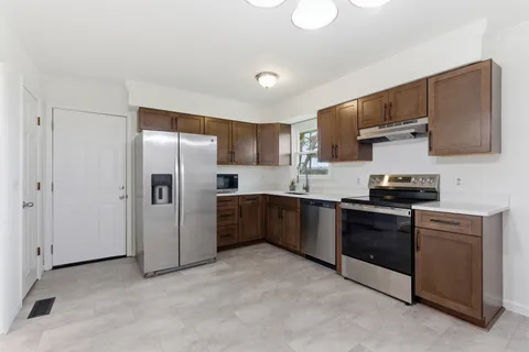 a kitchen with stainless steel appliances granite countertop a refrigerator stove and sink