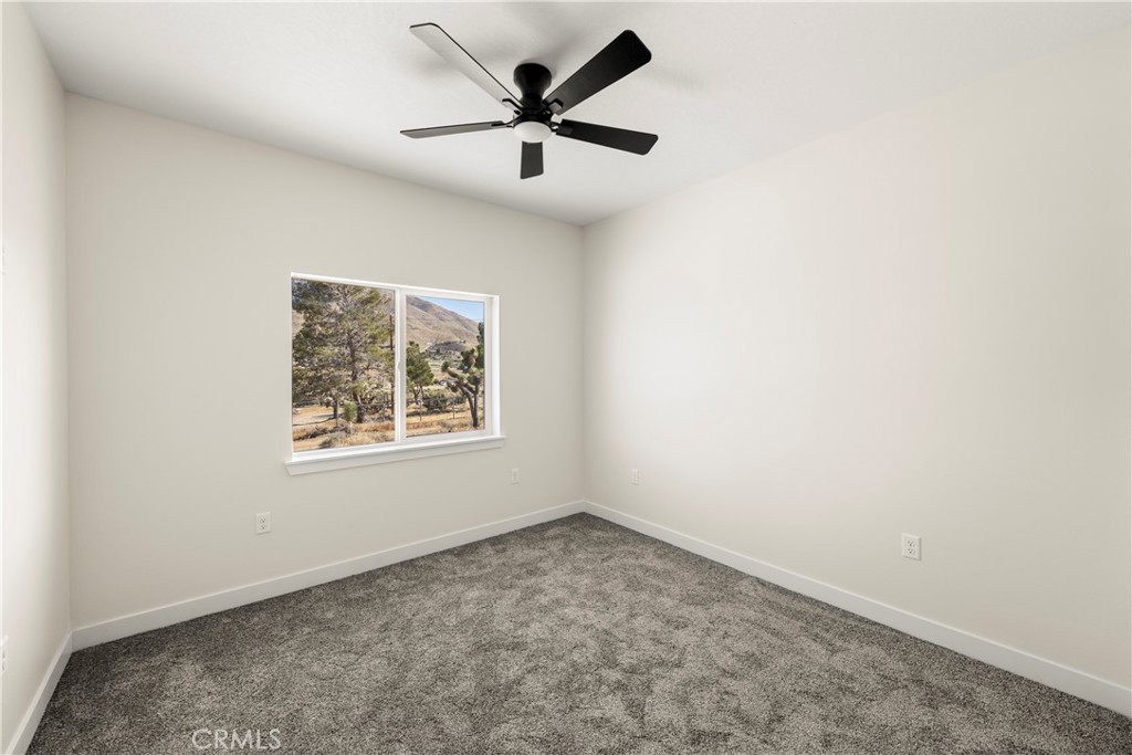 22324 Rancho Street Apple Valley, CA 92308 - Photo 32 of 47 an empty room with a window and a fan