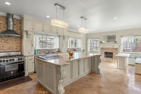a kitchen with kitchen island a stove a sink a center island and wooden floor