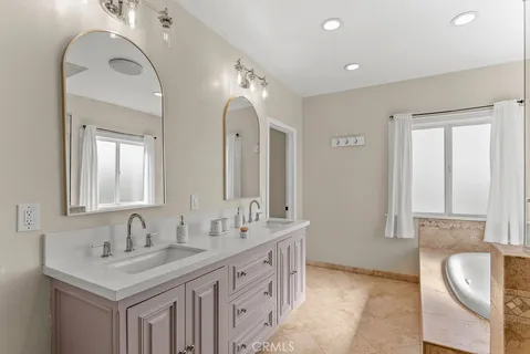 a bathroom with a granite countertop sink a toilet a large mirror and shower