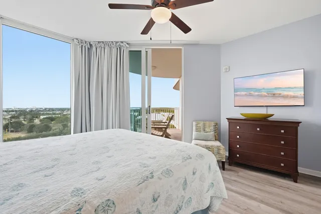 a bedroom with a bed a dresser and a chandelier