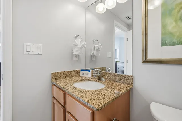 a view of a hallway with bathroom and wooden floor