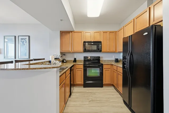 a kitchen with stainless steel appliances granite countertop a refrigerator stove and sink