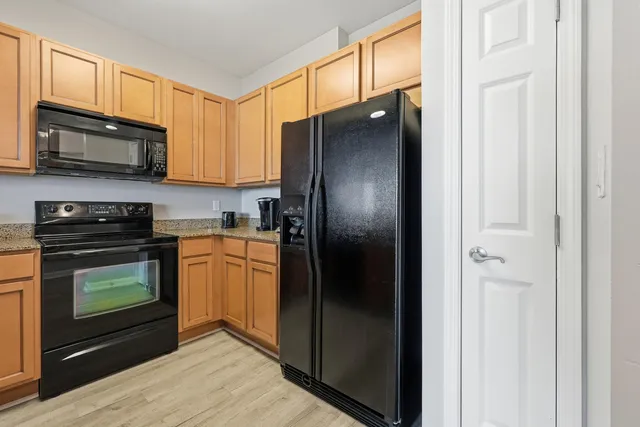 a kitchen with stainless steel appliances granite countertop a refrigerator stove and microwave