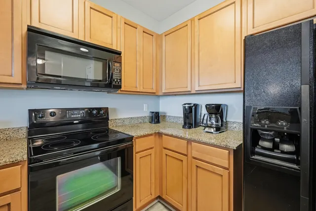 a kitchen with stainless steel appliances granite countertop a stove microwave and sink