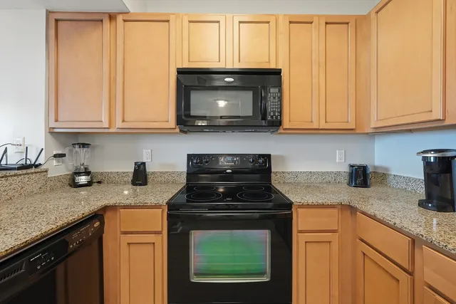 a kitchen with granite countertop a sink stove and cabinets