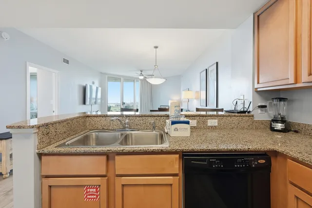 a kitchen with granite countertop a sink stainless steel appliances and cabinets