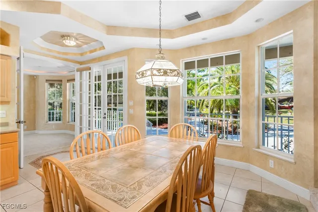 a dining room with furniture a chandelier and wooden floor