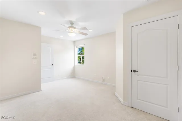 an empty room with a ceiling fan and a window