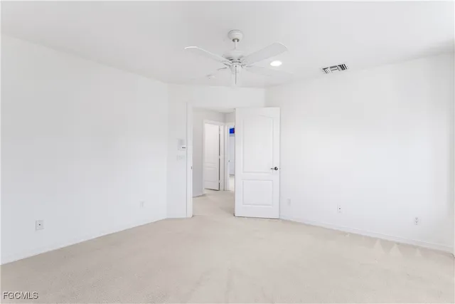 an empty room with an entryway and fan
