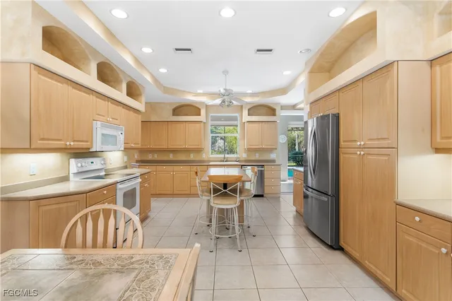 a kitchen with stainless steel appliances granite countertop a refrigerator and a sink