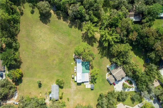 an aerial view of residential house with swimming pool and lawn chairs