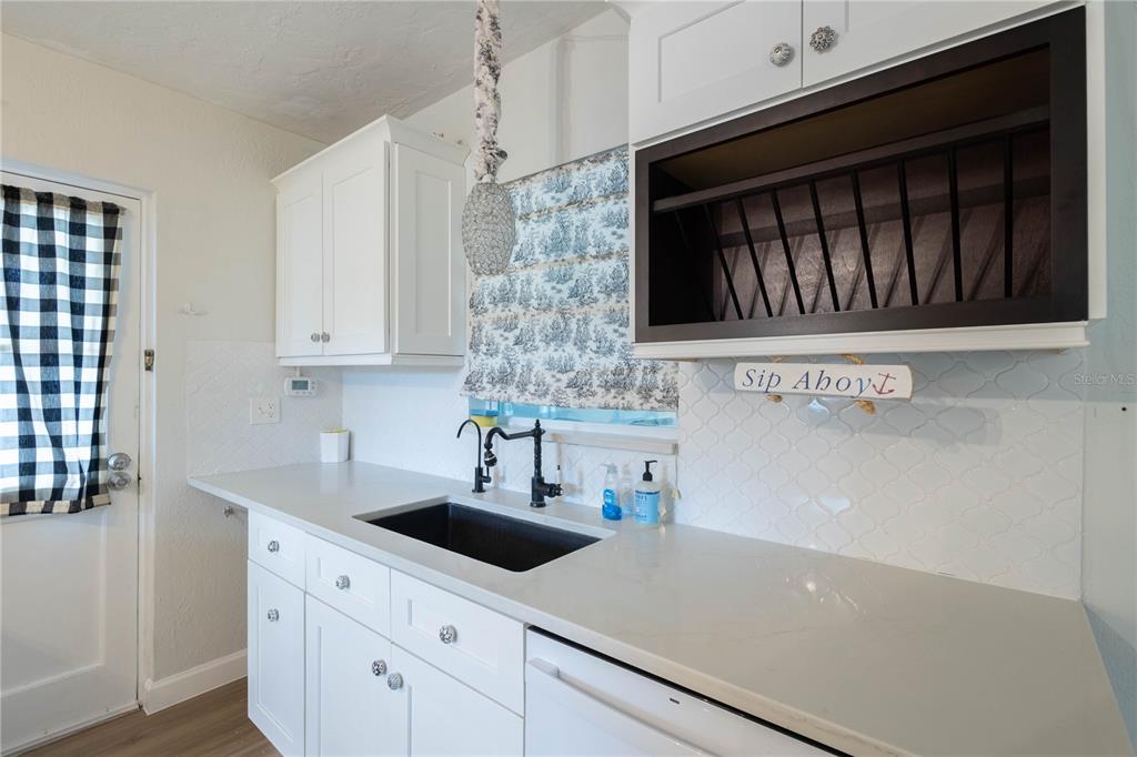 314 4th Avenue Southwest Ruskin, FL 33570 - Photo 8 of 30 a kitchen with stainless steel appliances granite countertop a sink dishwasher a stove and a microwave oven with white cabinets