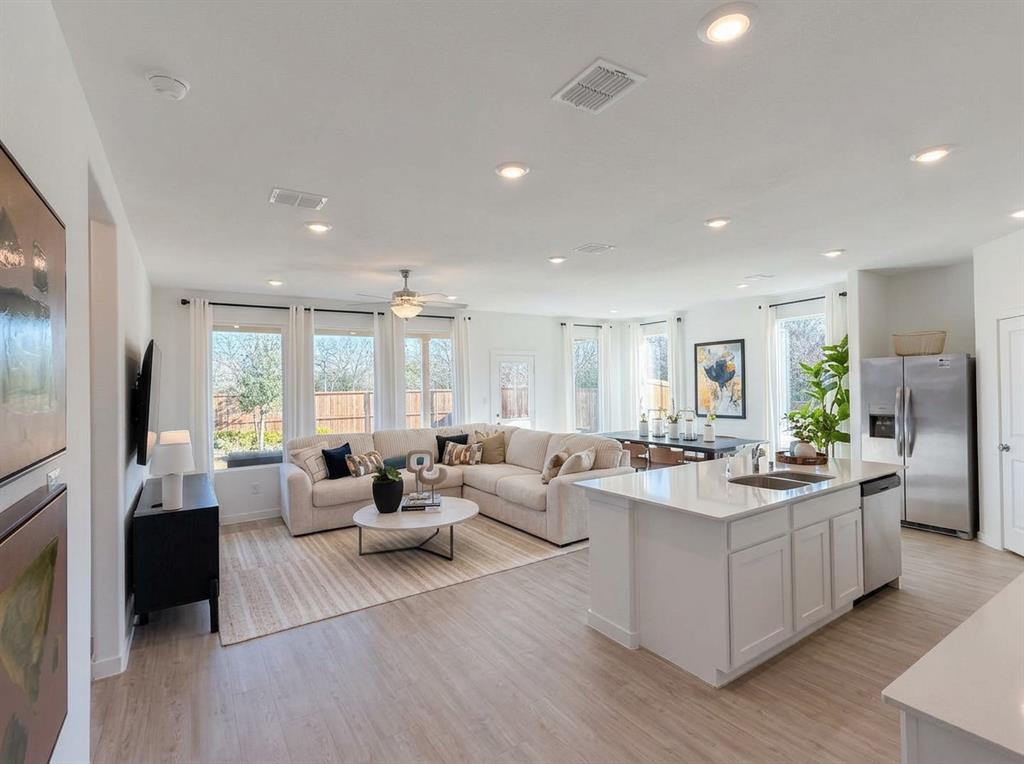 3017 Dutch Road Providence Village, TX 76227 - Photo 32 of 32 Kitchen with a kitchen island with sink, stainless steel appliances, open floor plan, white cabinetry, and light wood-style floors