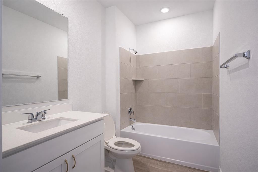 3017 Dutch Road Providence Village, TX 76227 - Photo 5 of 32 Full bathroom featuring vanity, shower / bath combination, light wood finished floors, and a textured wall