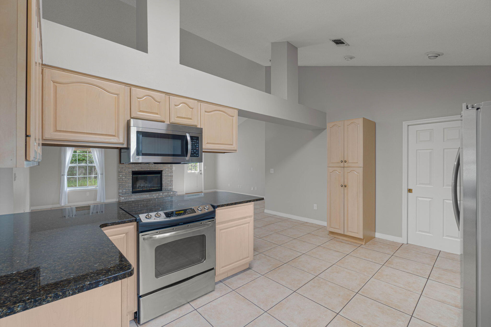 3816 Indigo Circle Destin, FL 32541 - Photo 14 of 36 a kitchen with granite countertop a stove a microwave and a refrigerator