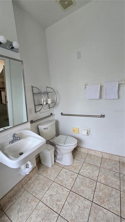 1013 Park Ridge Circle Kissimmee, FL 34746 - Photo 26 of 74 a bathroom with a toilet sink and mirror
