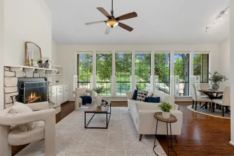 a living room with fireplace furniture and a large window