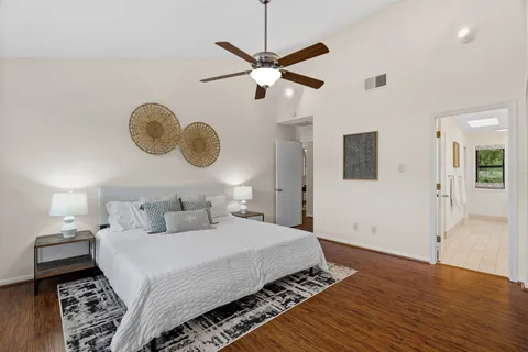 a kitchen with stainless steel appliances granite countertop a stove a sink and white cabinets with wooden floor